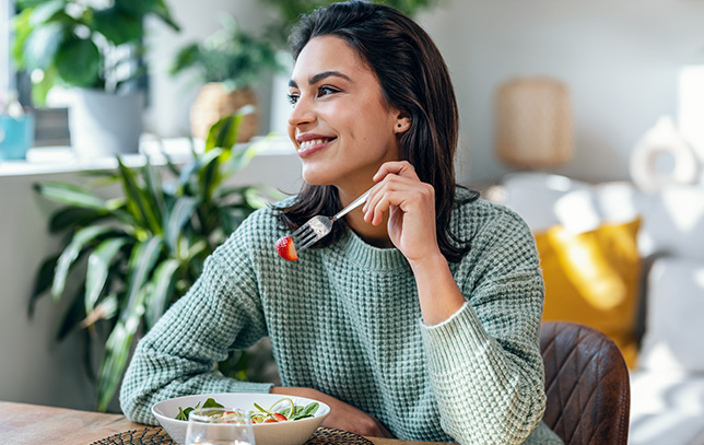 A lady eating a salad during a nutritional meal prepared by real chefs at Abseil Heights