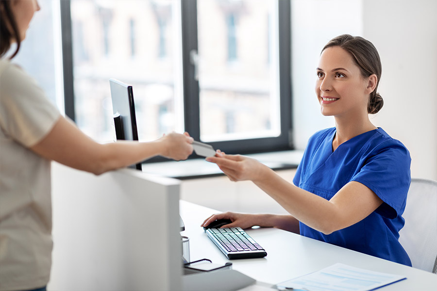 patient and admin at a desk going over health insurance